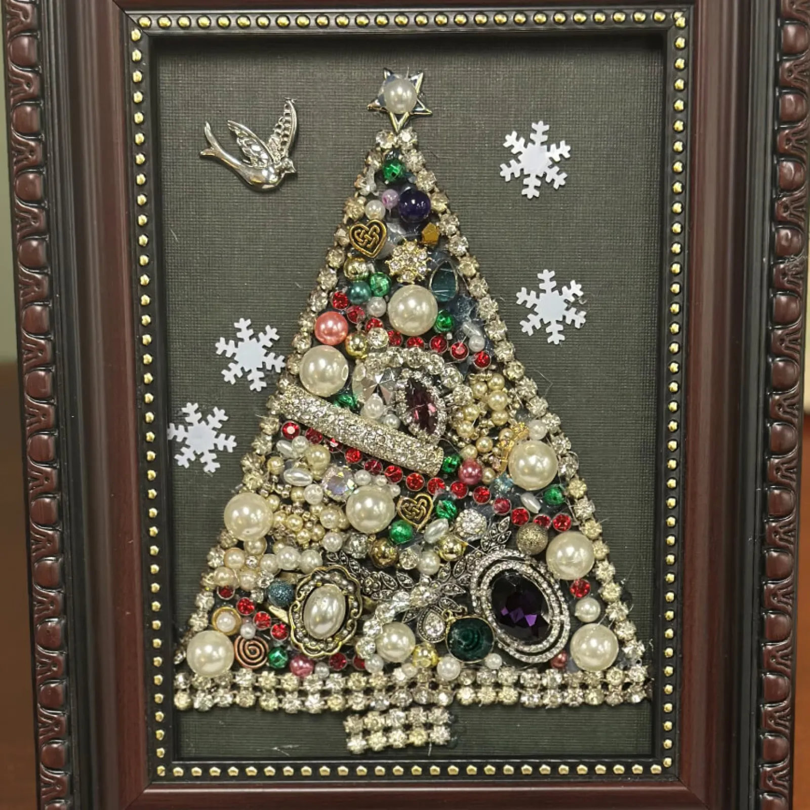 Framed jeweled Christmas tree art with snowflakes and a bird.