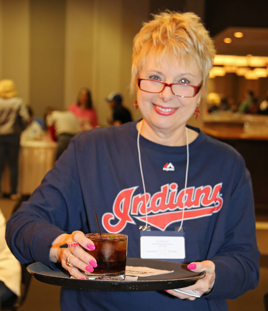 A volunteer serving a drink on a platter